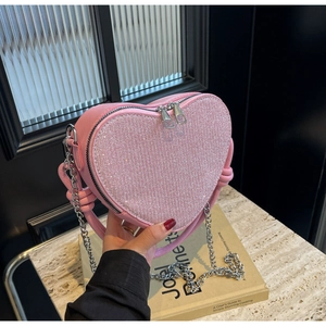 Detail of pink heart-shaped sequin handbag with silver zipper and chain strap