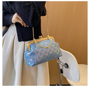 Detail of blue iridescent sequin evening bag with gold metal frame and handle