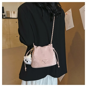 Dettaglio borsa a secchiello rosa con coulisse, catena dorata e ciondolo a mostro