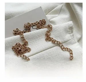 Detail of the high-quality gold metal chain strap on a woven summer beach crossbody bag