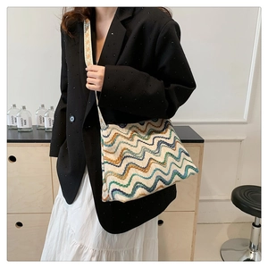 Detail of bohemian wavy knit tote bag with colorful geometric patterns and woven strap