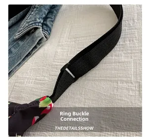 Detail of adjustable nylon strap and plastic buckle on floral print dumpling bag