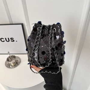 Fashionable black sequin bucket bag with silver chain strap for women in a modern setting
