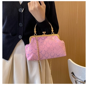 Pink sequin evening clutch bag with gold chain strap shown on a woman in a formal outfit