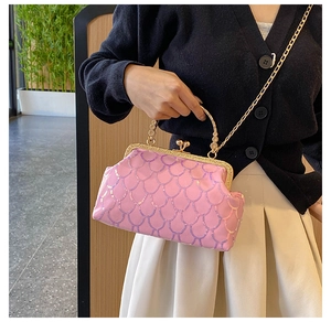Detail view of pink sequin evening bag with gold chain strap on a model outfit