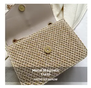 Detail showing the light gold metal magnetic clasp and woven texture of the straw bag