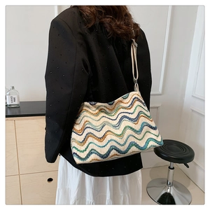 Detailed close-up of multi-color wavy textured woven tote bag with wide strap