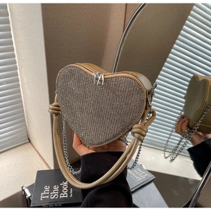 Detailed view of sequin heart-shaped bag with dual straps and polished silver hardware