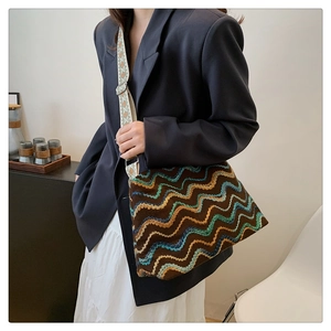 Detail of bohemian woven tote bag with wave patterns and wide jacquard shoulder strap