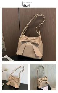 Détail d'un sac cabas kaki avec nœud décoratif, double bandoulière et texture cuir PU