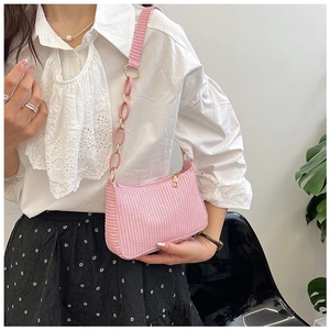 Detail of pink woven texture crescent bag with gold zipper and oversized plastic chain strap