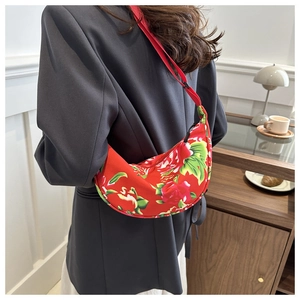 Detailed back view of a red floral crescent shoulder bag worn with a stylish blazer
