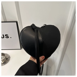 Detailed shot of a black heart-shaped handbag in smooth leather with elegant silver zipper