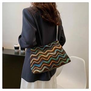 Close-up of bohemian wave pattern knit tote bag with vintage multicolor striped textures