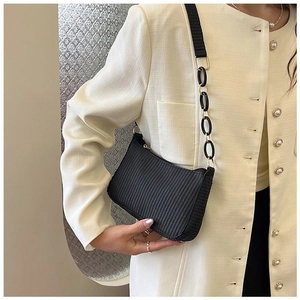 Detail showing black woven texture underarm bag with unique chain and nylon strap