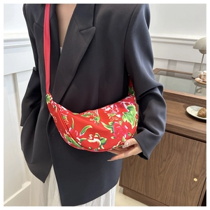 Detail of red floral crescent bag with traditional folk pattern and durable strap