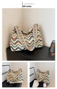 Detail of woven tote bag with wavy patterns and embroidered ethnic shoulder strap