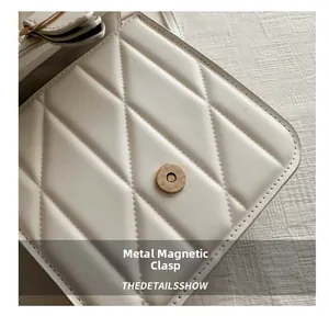 Close-up of beige quilted bag with magnetic metal buckle and fine stitching details