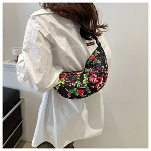 Detailed view of the vibrant floral dumpling bag worn as a crossbody shoulder bag