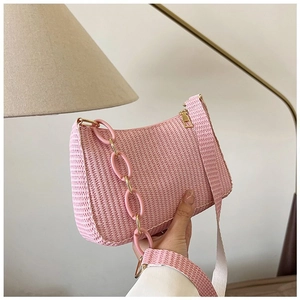 Detailed macro view of pink woven shoulder bag with resin chain and metallic zipper