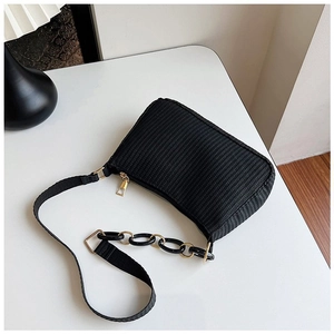 Close-up of woven texture and gold-tone chain strap on this black crescent shoulder bag