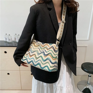Colorful Bohemian knit tote bag with wavy patterns and a wide ethnic strap on model