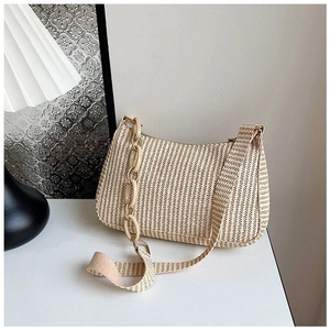 Detail of woven crescent shoulder bag with acrylic chain and wide braided strap in beige