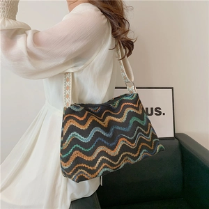 Retro chic tote bag with colorful wave jacquard pattern and wide strap shown on a model