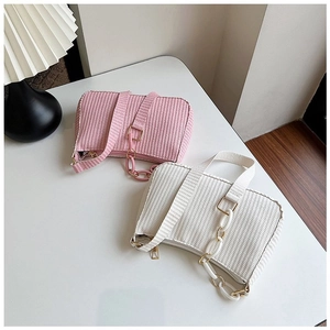 Close-up of pink and white woven hobo bags with decorative chunky acrylic chain detail