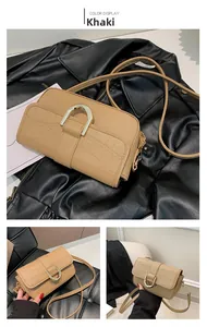 Detail of khaki faux-crocodile shoulder bag with gold U-shaped metal buckle design