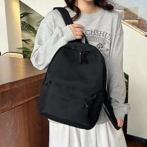 Sac à dos noir minimaliste pour étudiant en nylon durable porté par un mannequin