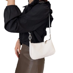 White woven baguette shoulder bag with minimalist chic design and gold zip closure