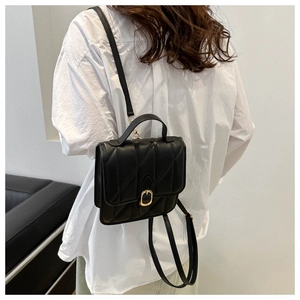 Close-up of a black quilted leather backpack for women with golden D-ring buckle detail