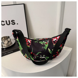 Detail of floral crossbody bag with vibrant red and green pattern on high-density nylon