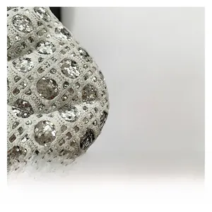Detailed close-up of high-quality knit fabric with shiny silver sequins on a white bag