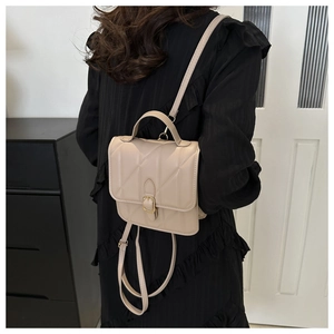 Beige quilted backpack with metal clasp shown in a lifestyle indoor setting