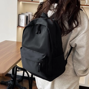 Vue latérale du sac à dos en nylon noir montrant le compartiment et la poche sur un mannequin