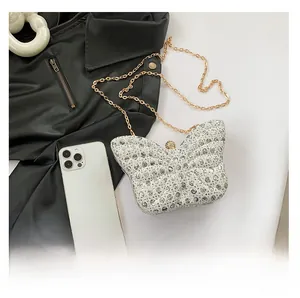 Detailed view of sparkly butterfly evening bag with rhinestones and gold chain strap