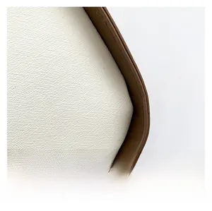 Detail aus weißem Canvas-Stoff mit hochwertigem braunem Lederbesatz und Nähten