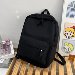 Détail du sac à dos scolaire noir avec doubles fermetures éclair sur banc en bois