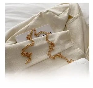 Détail du sac à main blanc matelassé avec une chaîne dorée et une texture élégante