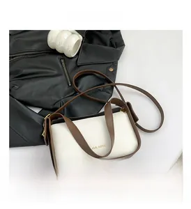 Flachbild der cremefarbenen Denim-Tasche mit braunen Riemen und goldenem Rich Rabbit-Logo