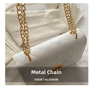 Gros plan du maillon de chaîne doré et du cuir blanc matelassé du sac bandoulière