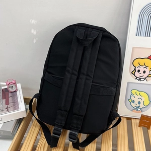 Vue détaillée du dos du sac à dos noir avec de larges bretelles rembourrées et poignée supérieure