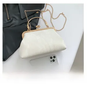 Detailed top view of a pearl marble texture evening bag next to a phone for size comparison
