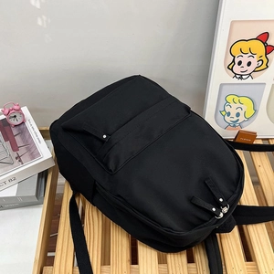 Vue de dessus du sac à dos minimaliste en nylon noir avec doubles fermetures éclair