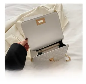 Détail intérieur d'un sac à bandoulière matelassé blanc montrant l'espace smartphone