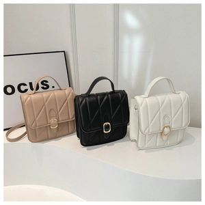 Detailed view of three quilted leather handbags with metal buckles and top handles