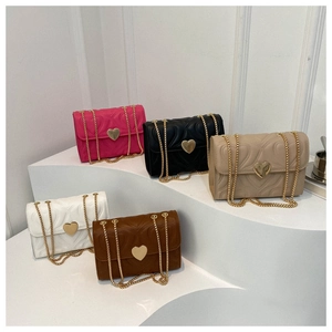 Detalle de bolsos bandolera acolchados con hebillas de corazón dorado en varios colores
