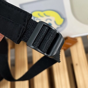 Détail de la sangle en nylon noir et de la boucle de réglage en plastique sur le sac à dos